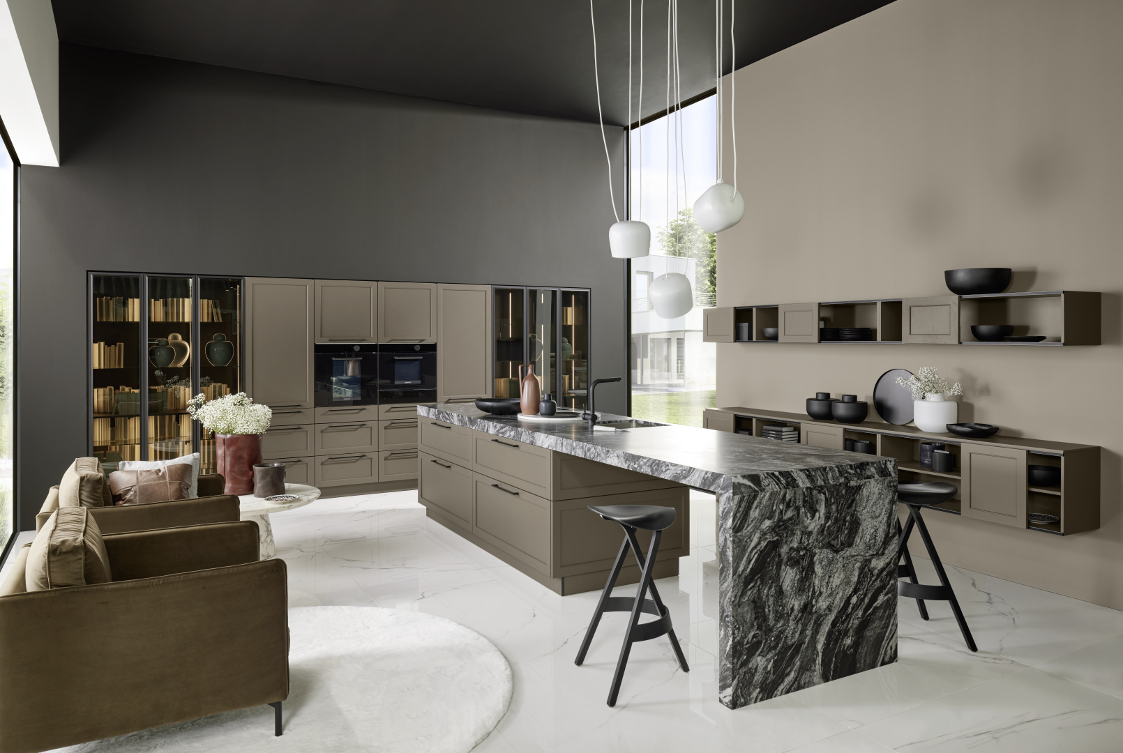 Wohnküche grau mit Glasvitrinen, Kücheninsel mit Theke als Verlängerung der Arbeitsplatte dunkel marmoriert, Sessel und Sideboards